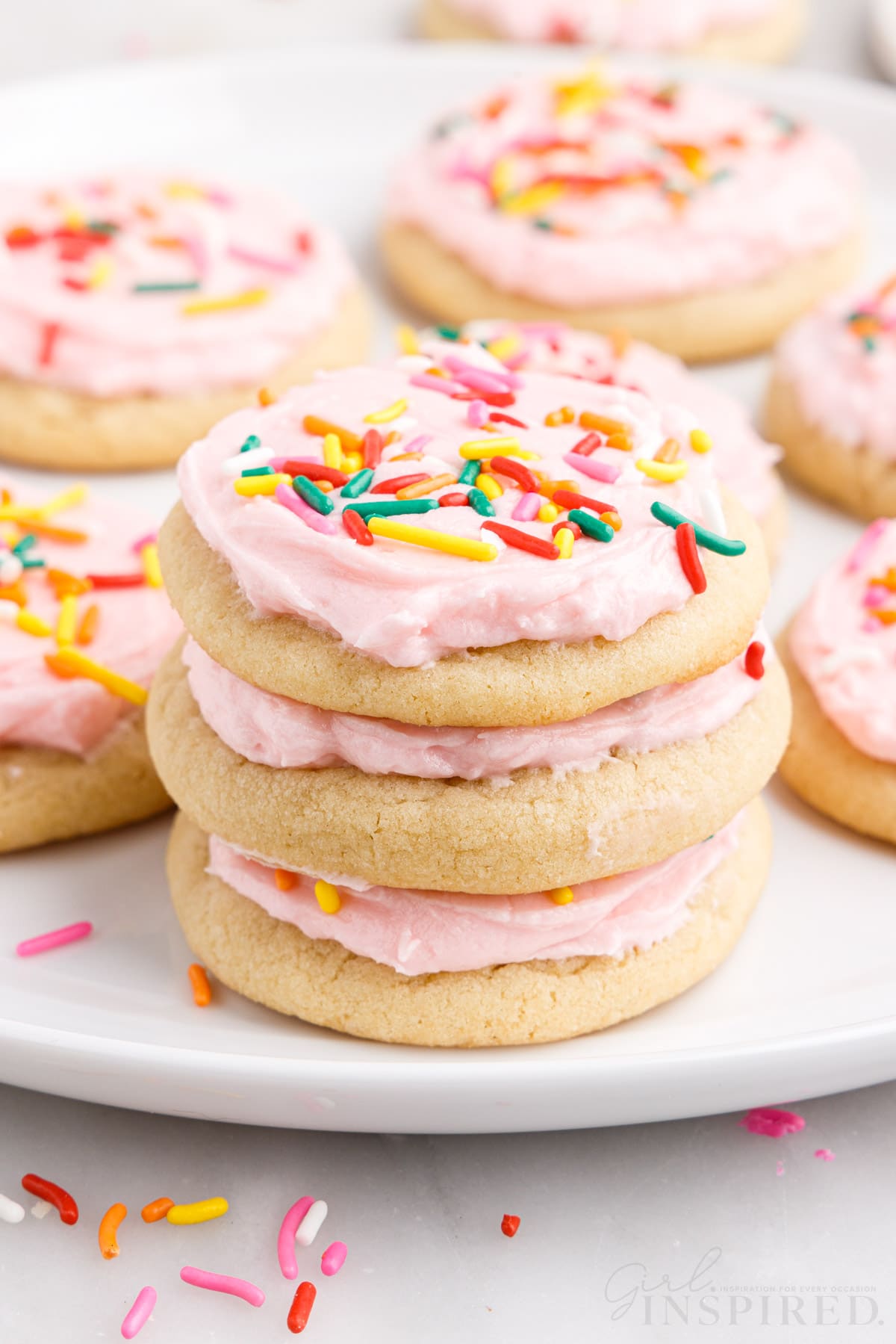 three soft baked frosted sugar cookies stacked on each other