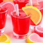 pink lemonade jello shots with a lemon on side of the cup