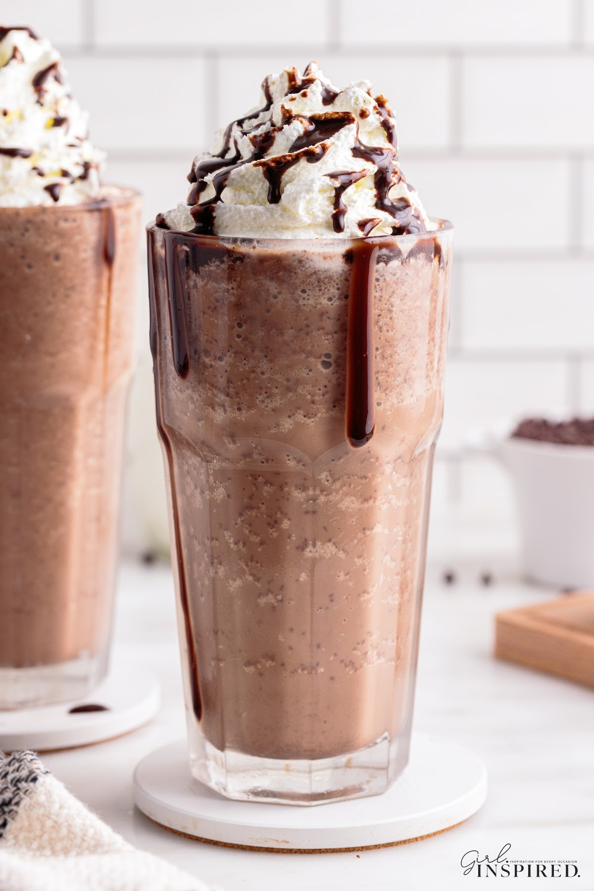 Double chocolate chip frappuccino in a glass with whipped cream and chocolate drizzle.