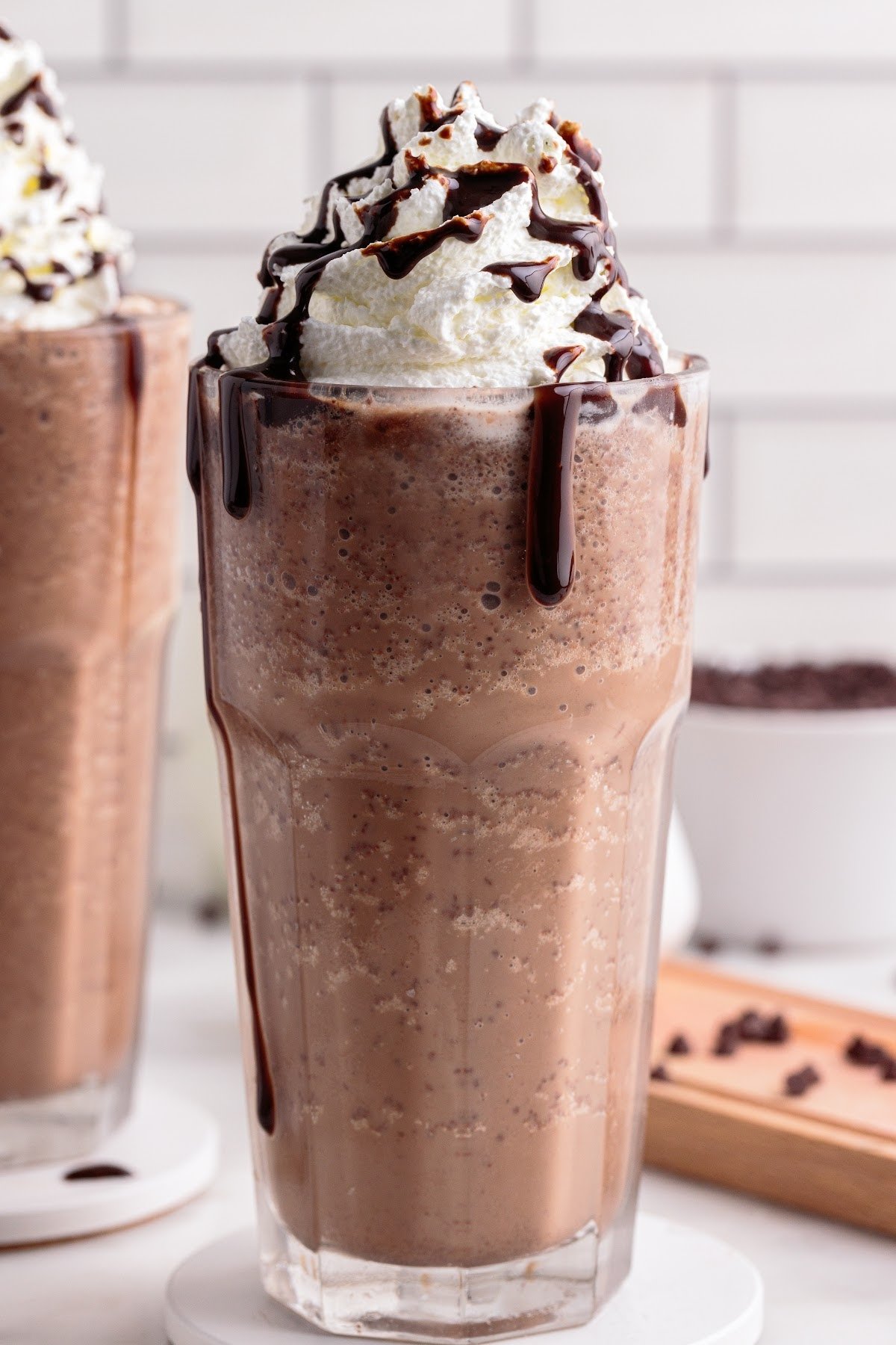 Double chocolate chip frappuccino in a glass with whipped cream and chocolate drizzle.