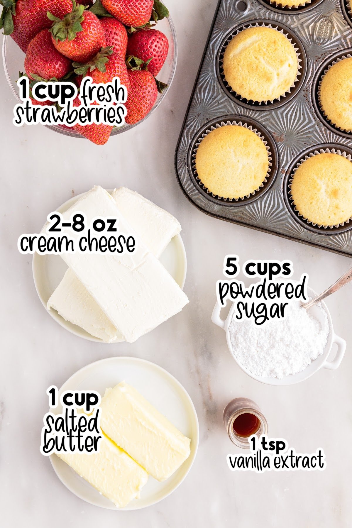 Bowl of strawberries, blocks of cream cheese, cubes of butter, dish of powdered sugar and vanilla extract, with muffin tray of cupcakes, with text and amount labels for the ingredients to make strawberry cream cheese frosting.