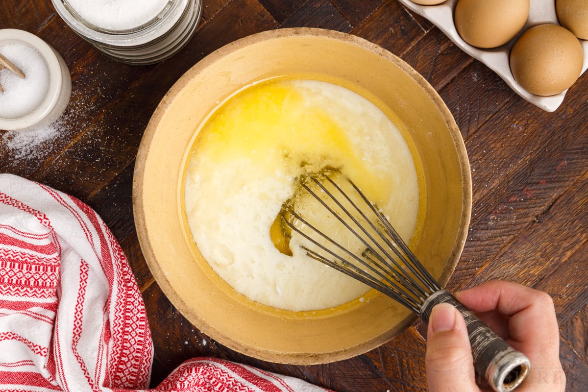 whisking together cornbread ingredients in a mixing bowl