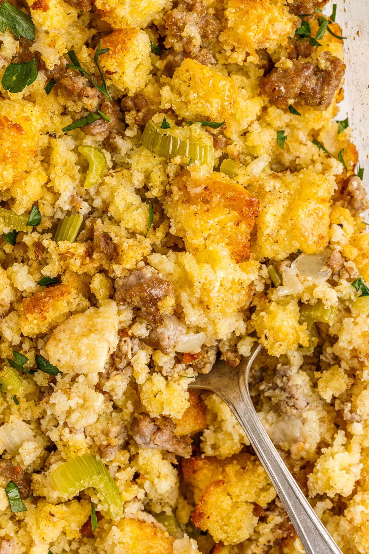 top view of cornbread sausage stuffing with a spoon inserted