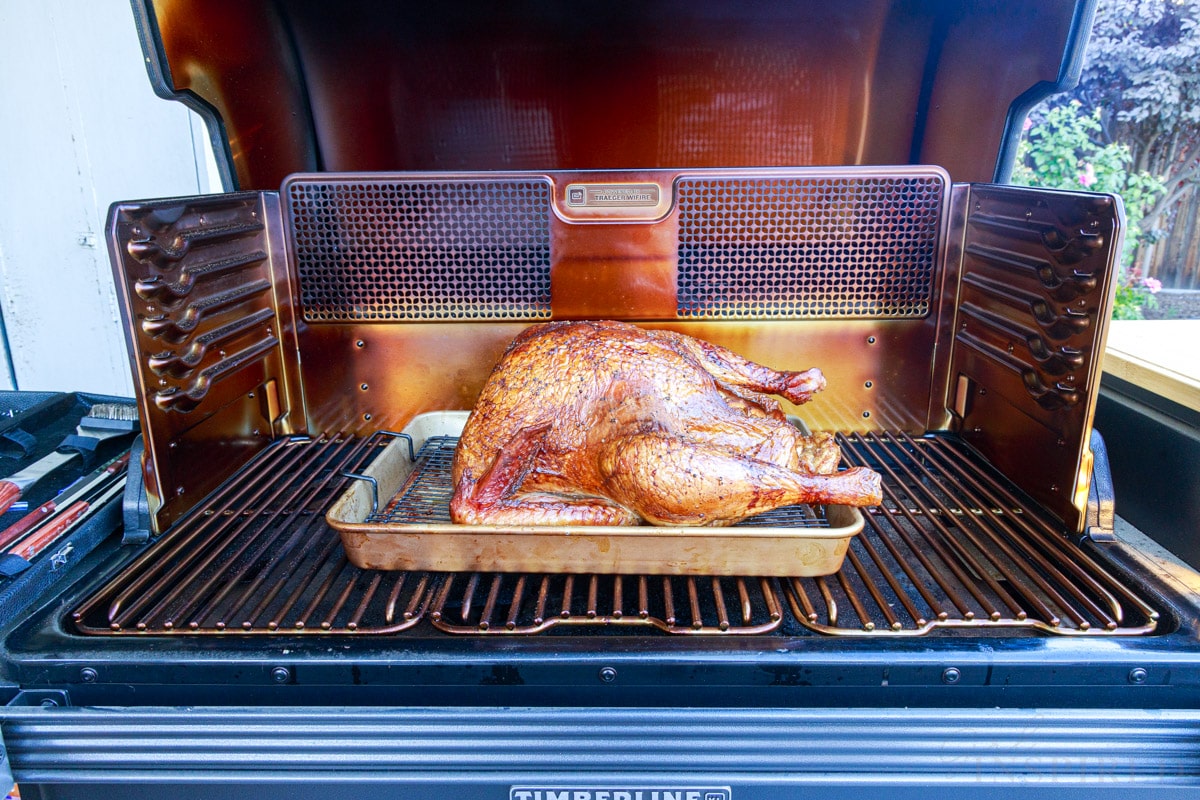 browned turkey in a pan on an opened smoker