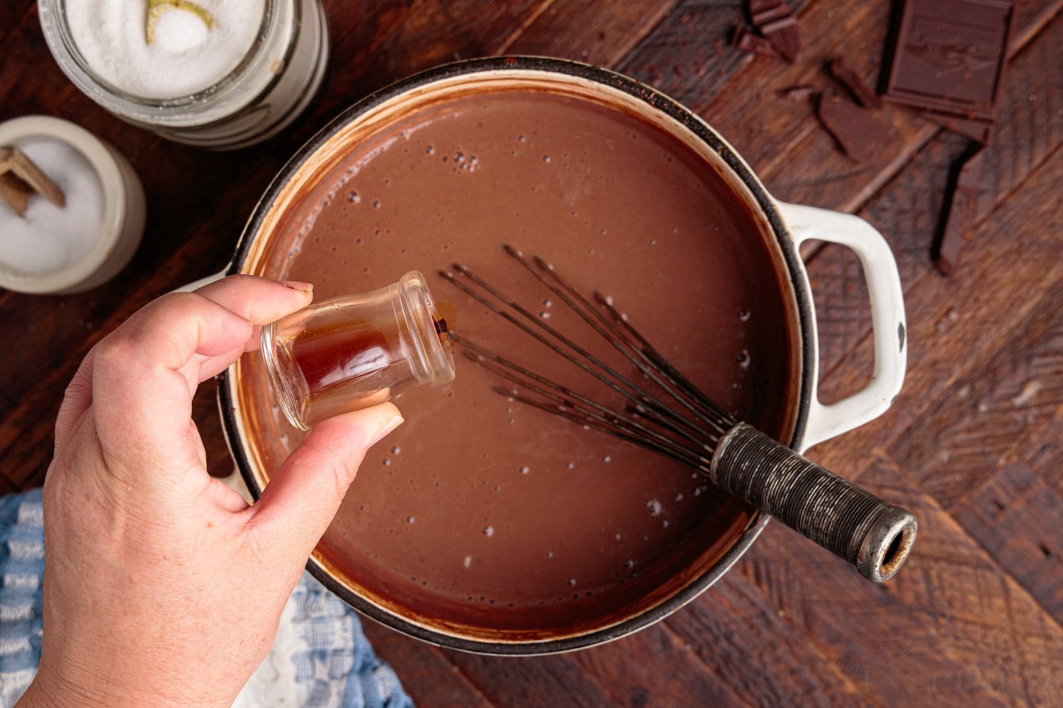 vanilla extract being added into the chocolate mixture in a sauce pan