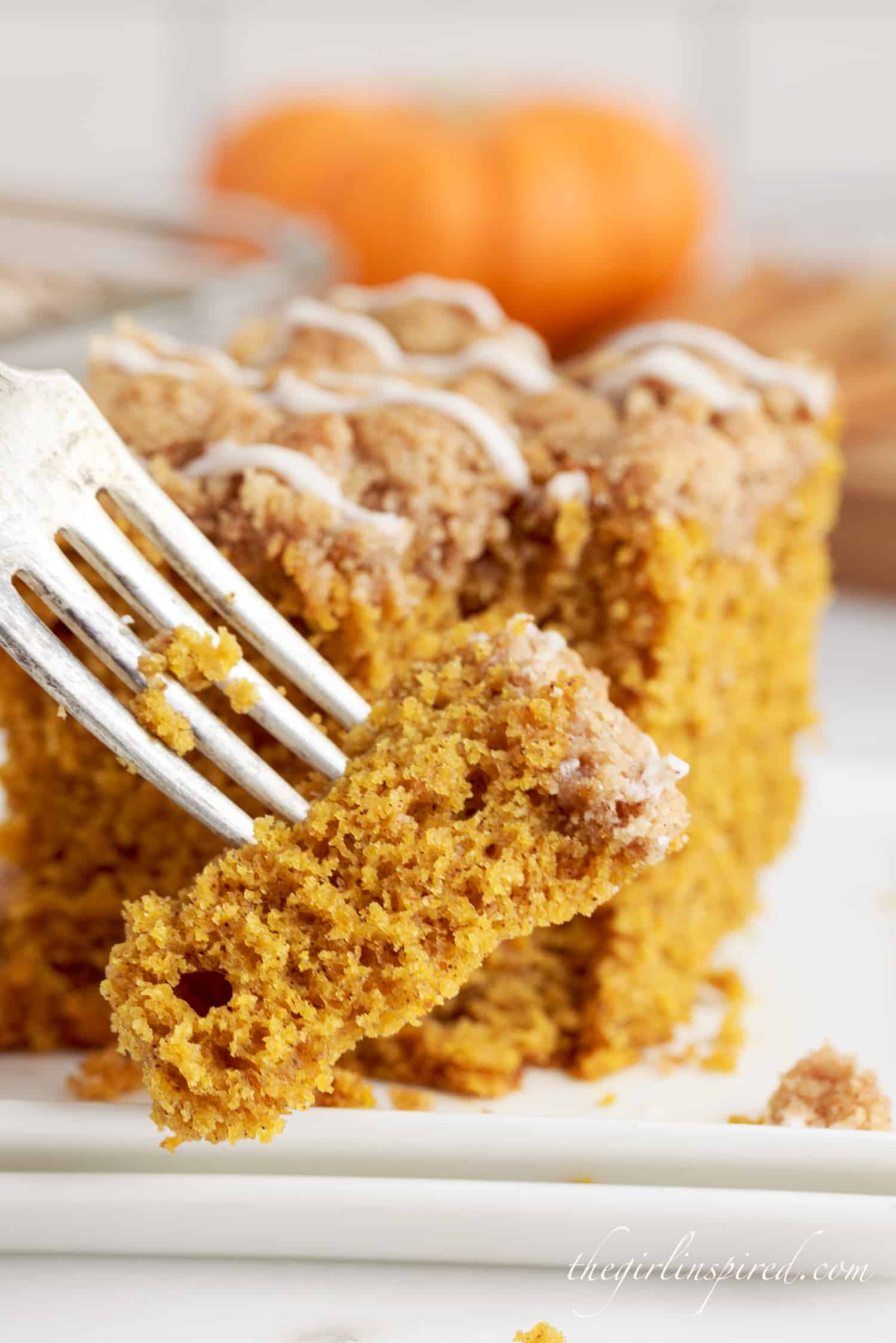 a close up of a fork full of pumpkin coffee cake