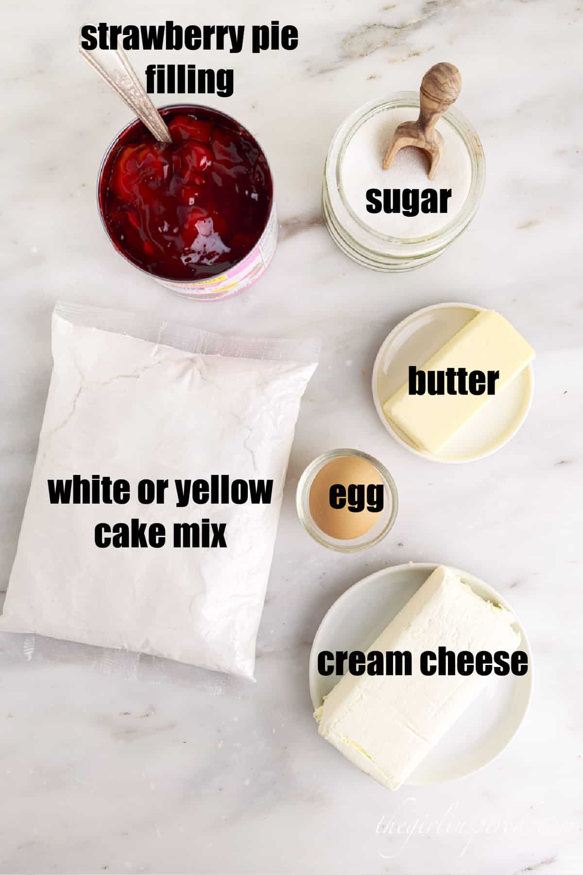 individual ingredients for strawberry cheesecake dump cake with text labels.