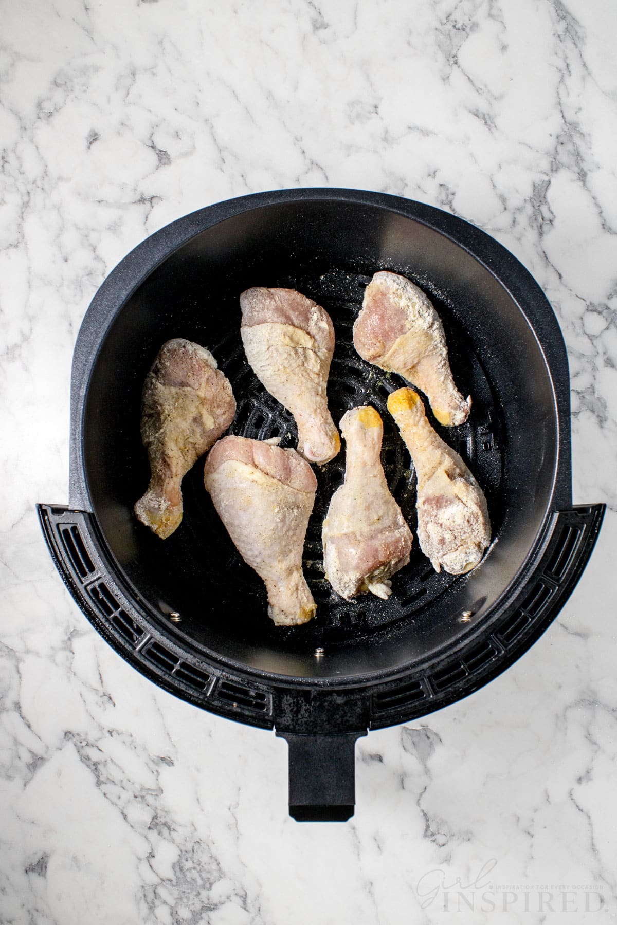 top view of chicken legs in an air fryer for bbq chicken legs