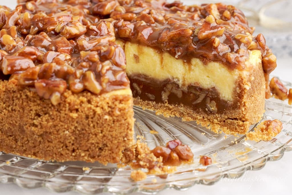 front close up of caramel pecan pie cheesecake with a slice missing