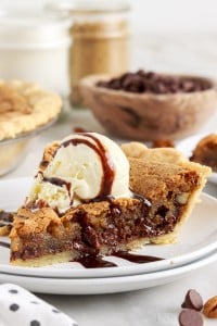 a slice of chocolate chip pie with vanilla ice cream on two small plates