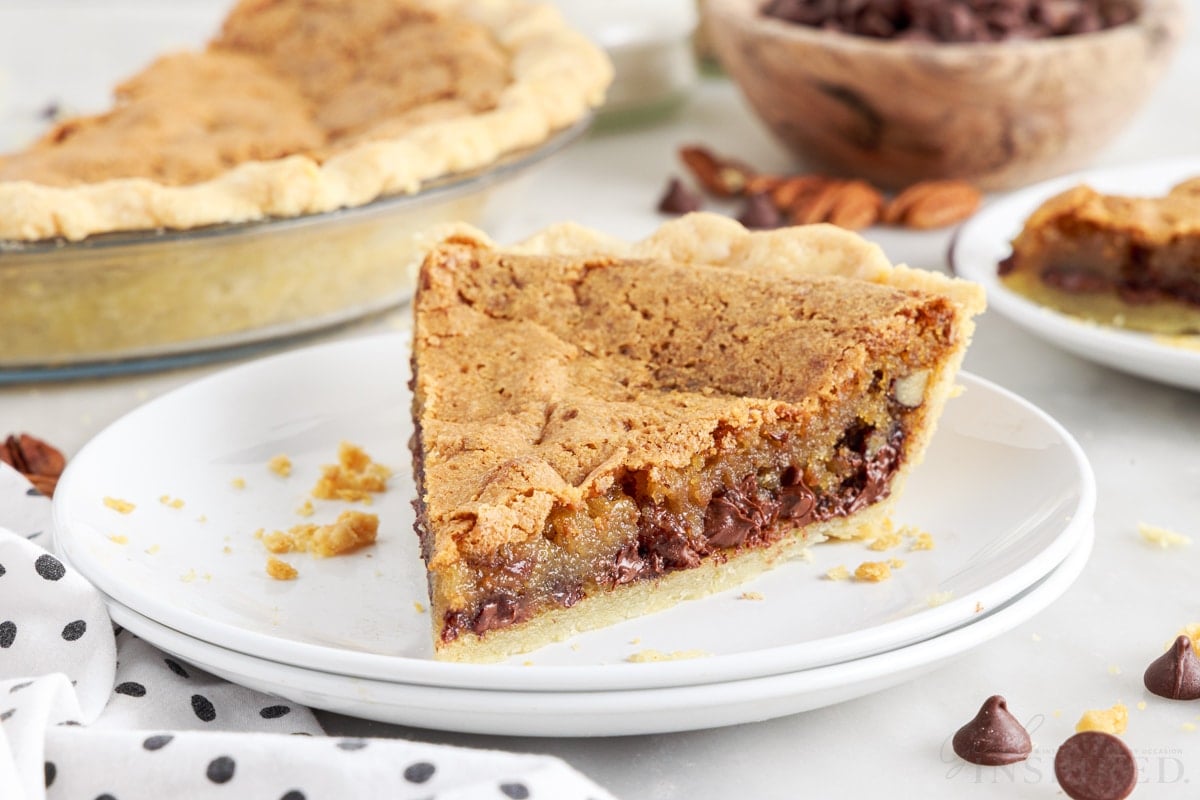 a slice of chocolate chip pie on two stacked white plates