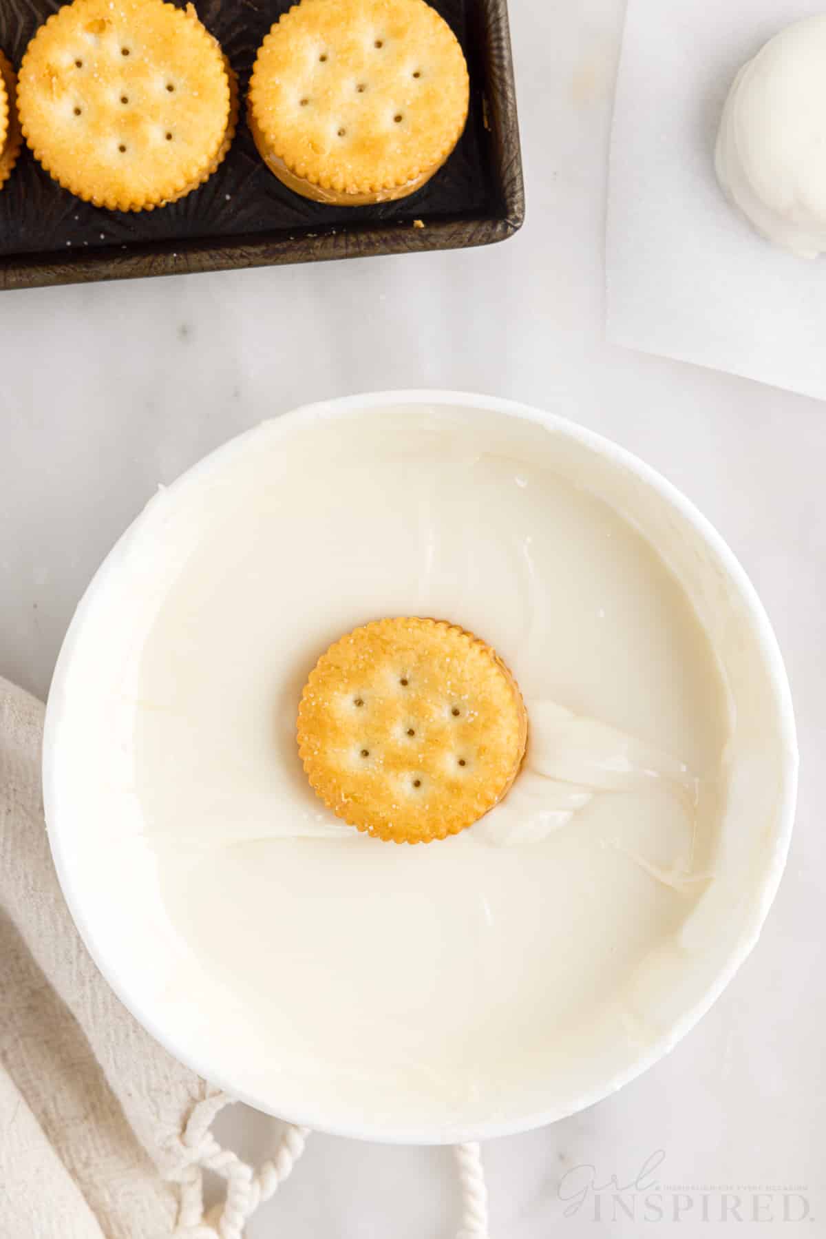 on ritz cracker sitting on top of the melted white chocolate
