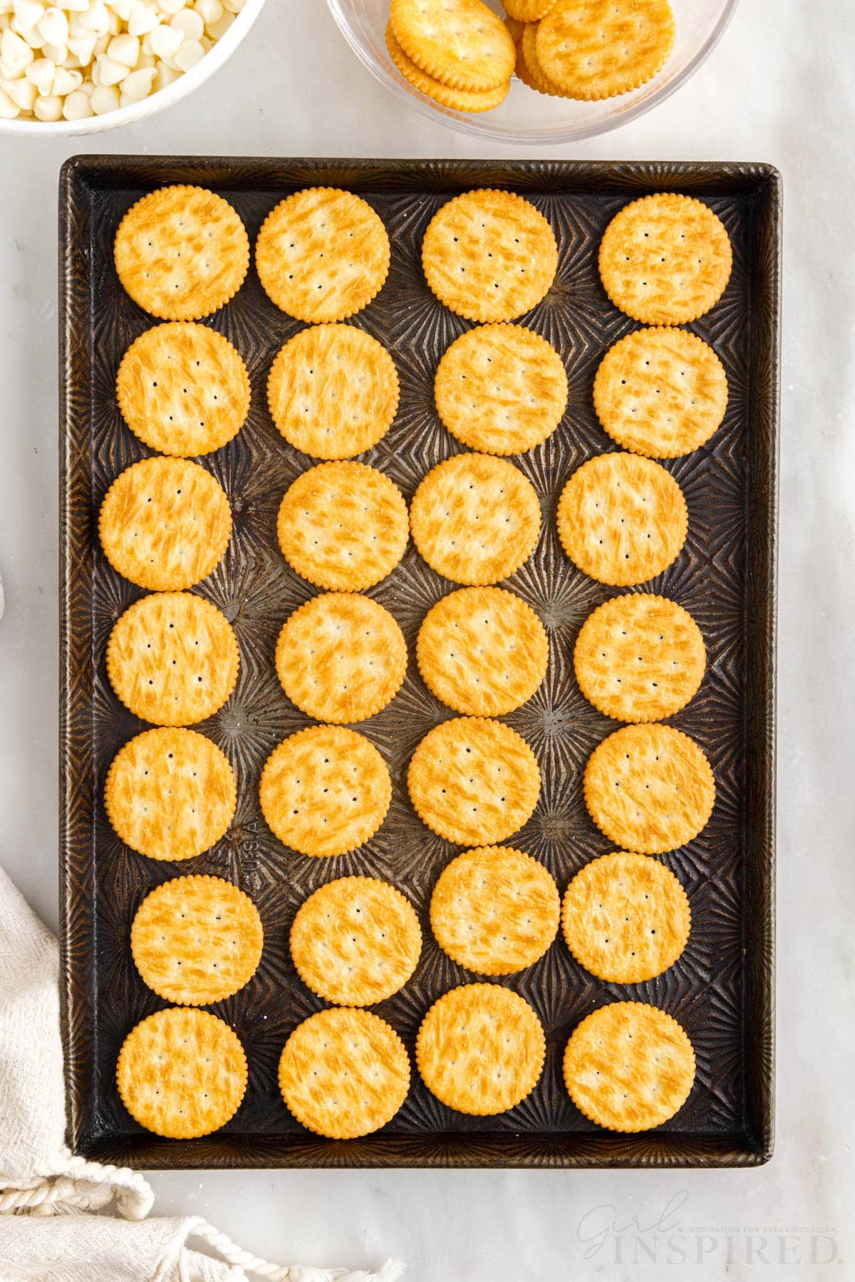 top view of twenty eight ritz cookies laid out on a decorative metal cookie sheet
