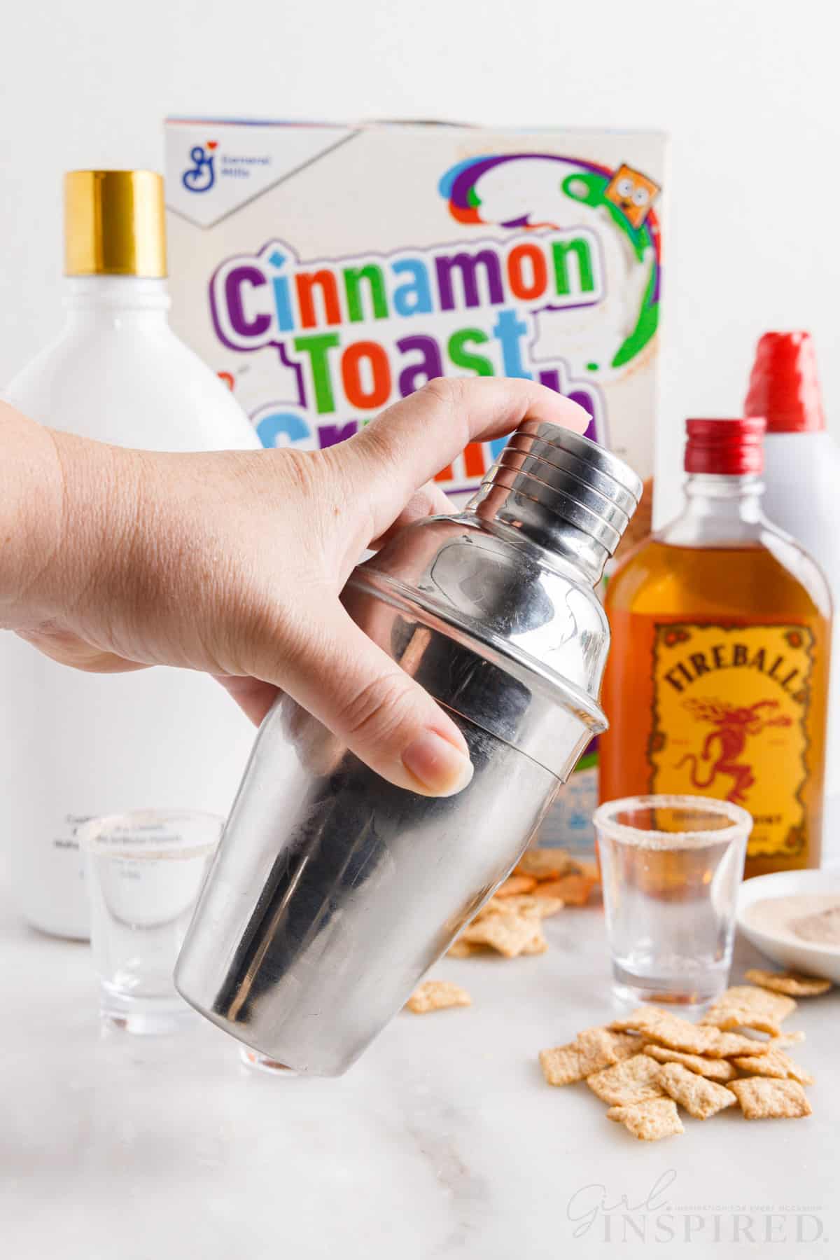 Cinnamon toast crunch shot mixture being shook in a shaker.