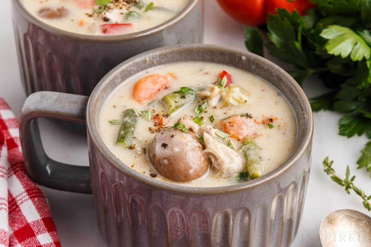 side view of creamy chicken stew in a small soup cup