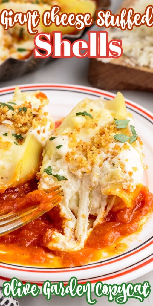 two giant cheese stuffed shells served on a serving plate with red sauce and a fork placed in front of them