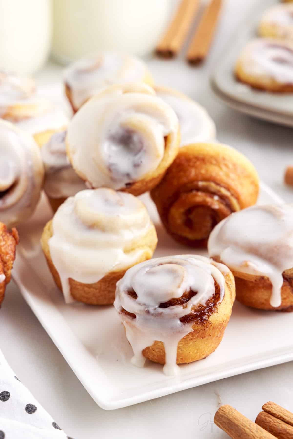 mini cinnamon rolls stacked on a white serving platter