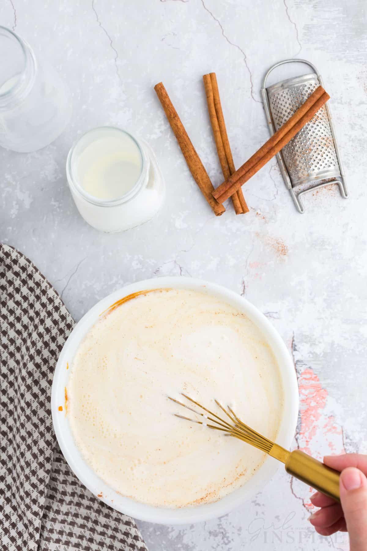 milk and cream being stirred into the pumpkin ice cream base.