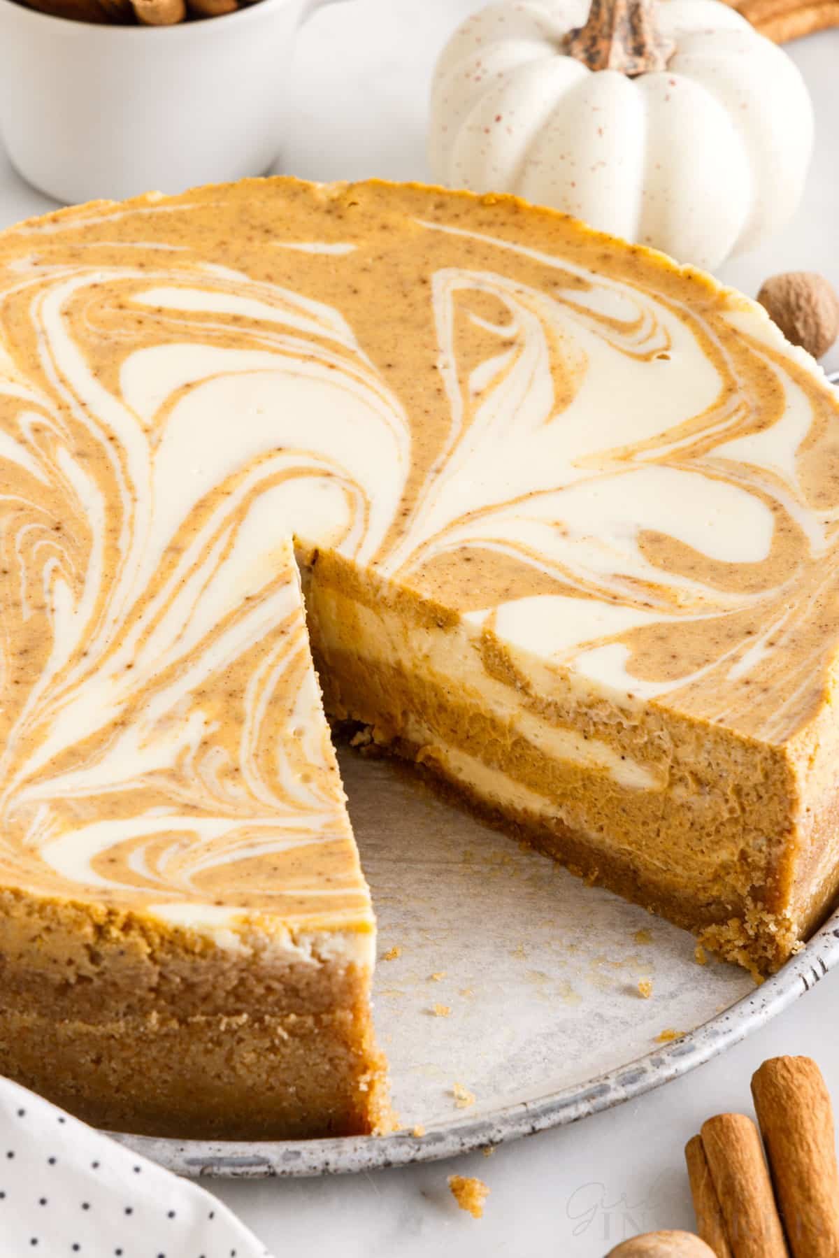 front view of pumpkin swirl cheesecake with a slice missing
