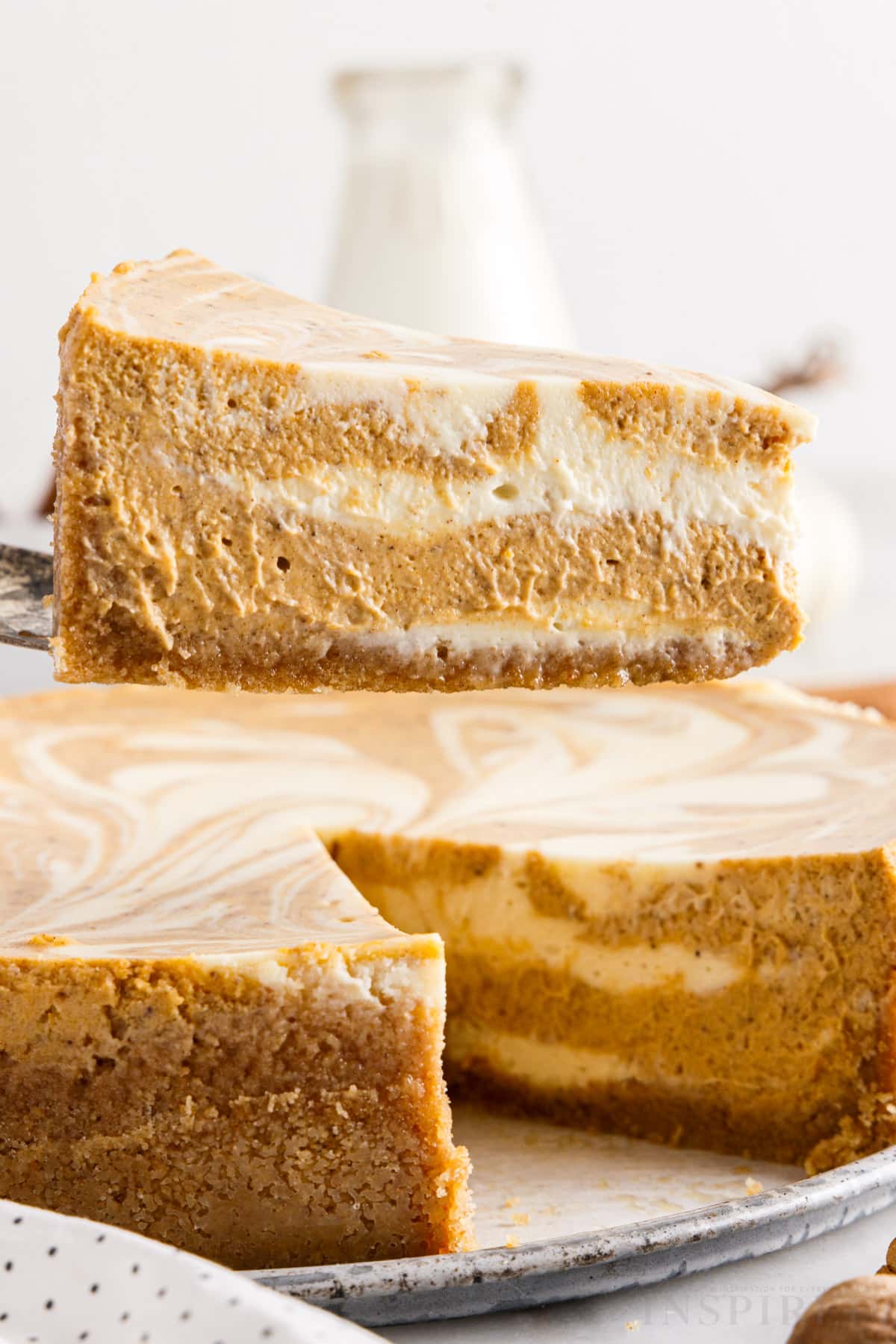 a slice of pumpkin swirl cheesecake lifted from the cheesecake