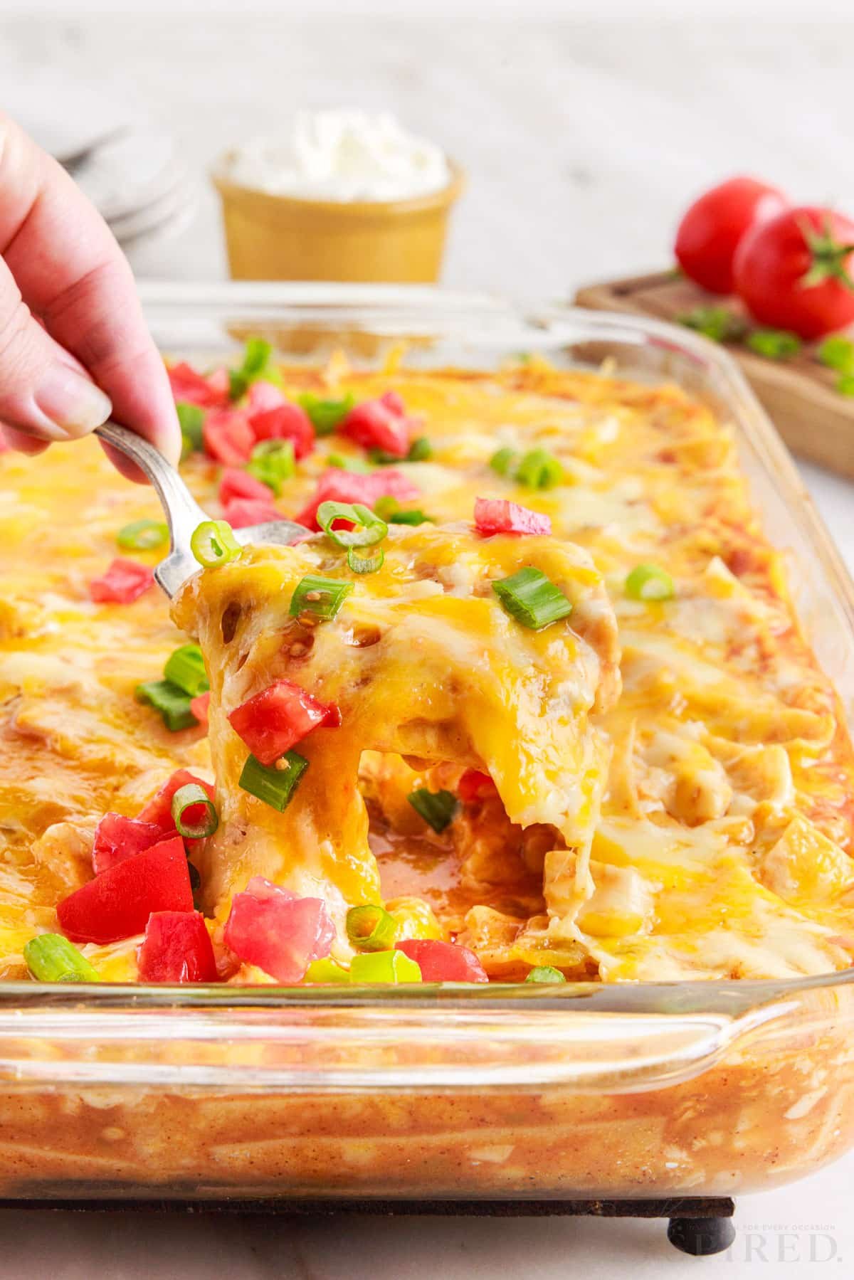 a fork full of turkey enchilada casserole lifted out of 9x13