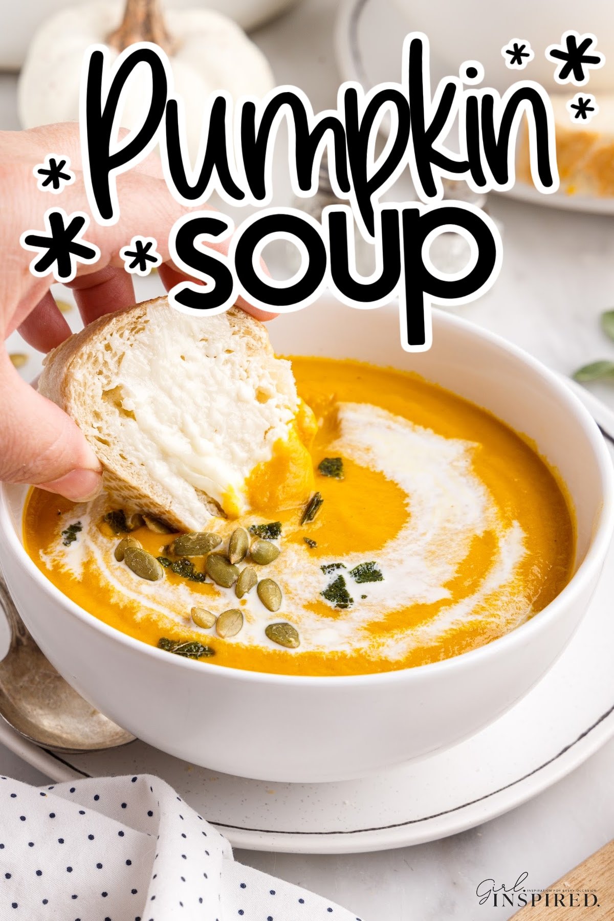 Homemade pumpkin soup made with canned pumpkin topped with pepitas with a piece of bread being dipped in, with text title,
