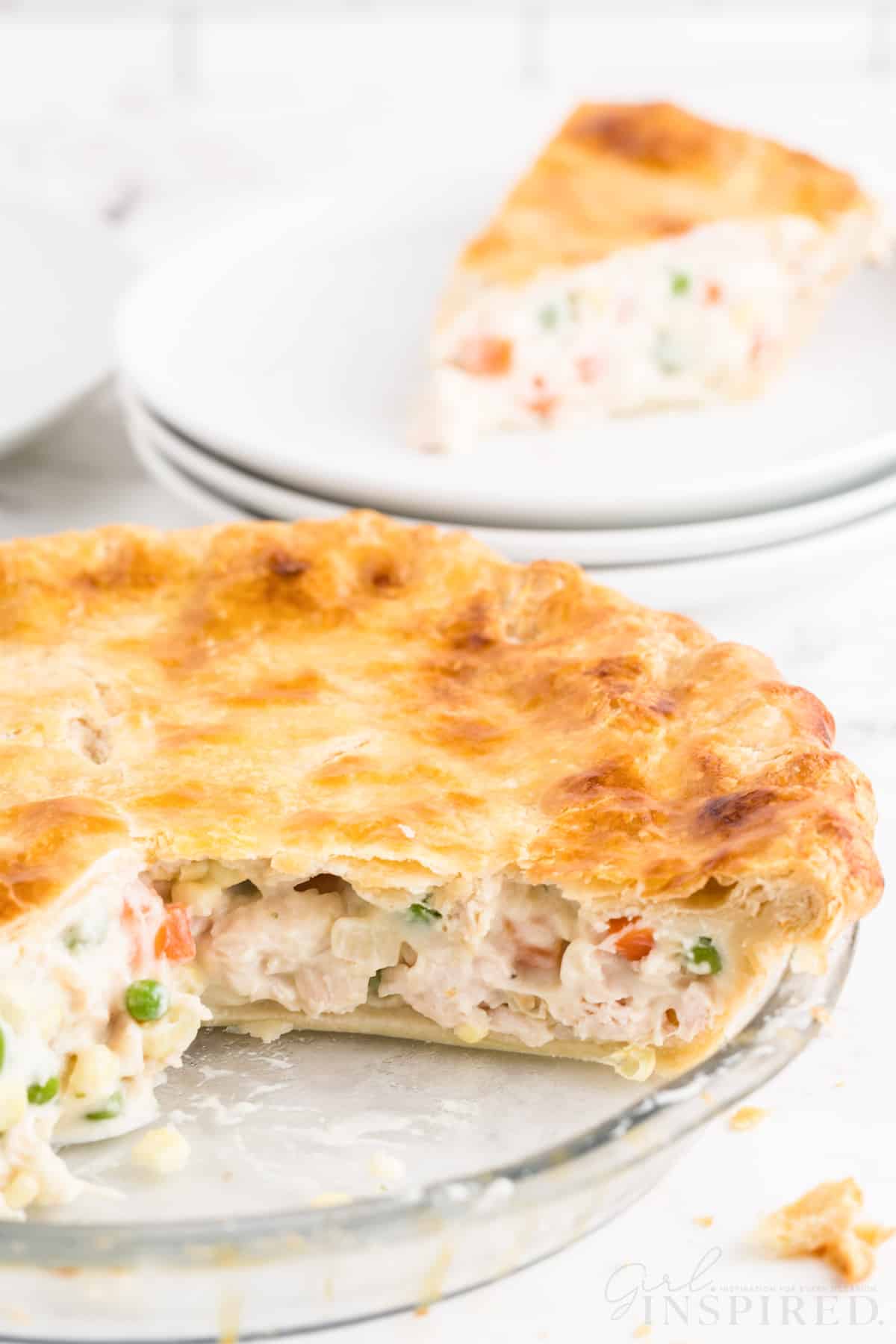 Easy chicken pot pie with slices removed and a piece of pie on white plates.
