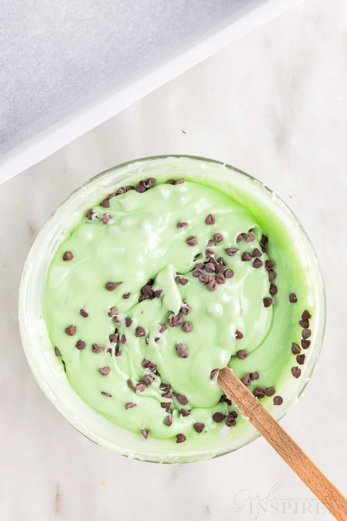 chocolate chips mixed into the mint chocolate chip fudge mixture in a mixing bowl