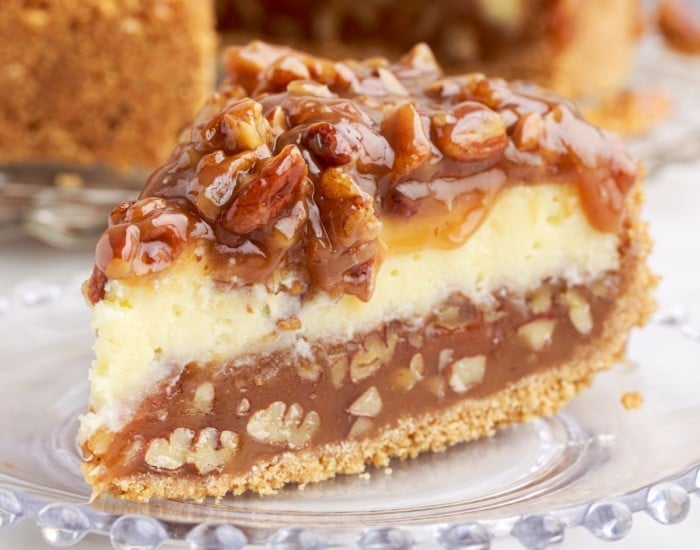 slice of caramel pecan pie cheesecake on a small plate