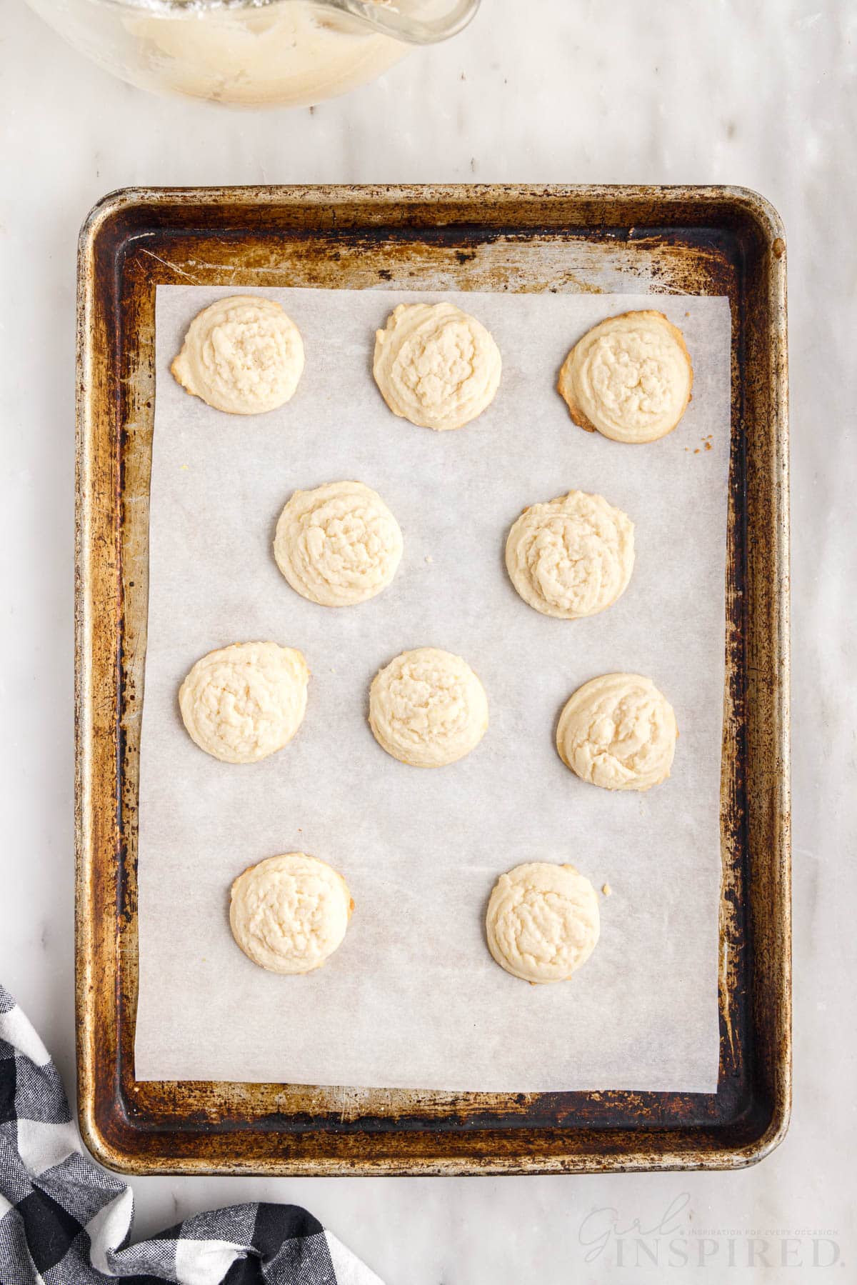 a parchment paper lined cookie sheet with amish sugar cookies on it