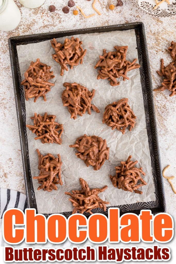 a parchment lined tray of chocolate butterscotch haystacks with recipe ingredients positioned around and a striped cloth next to the tray