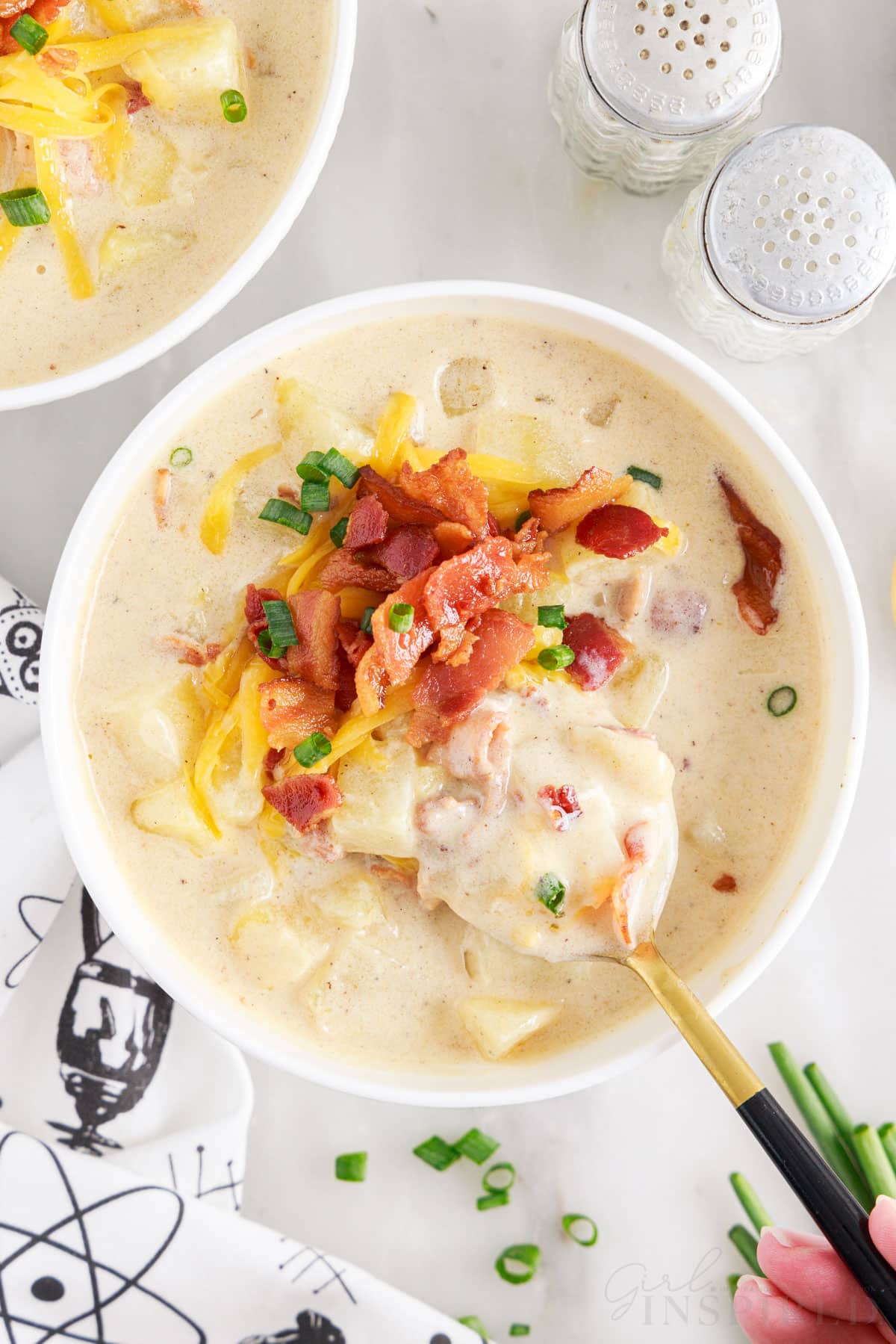 a spoon in a bowl of baked potato soup