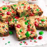 Christmas cookie bar squares set out on parchment paper.