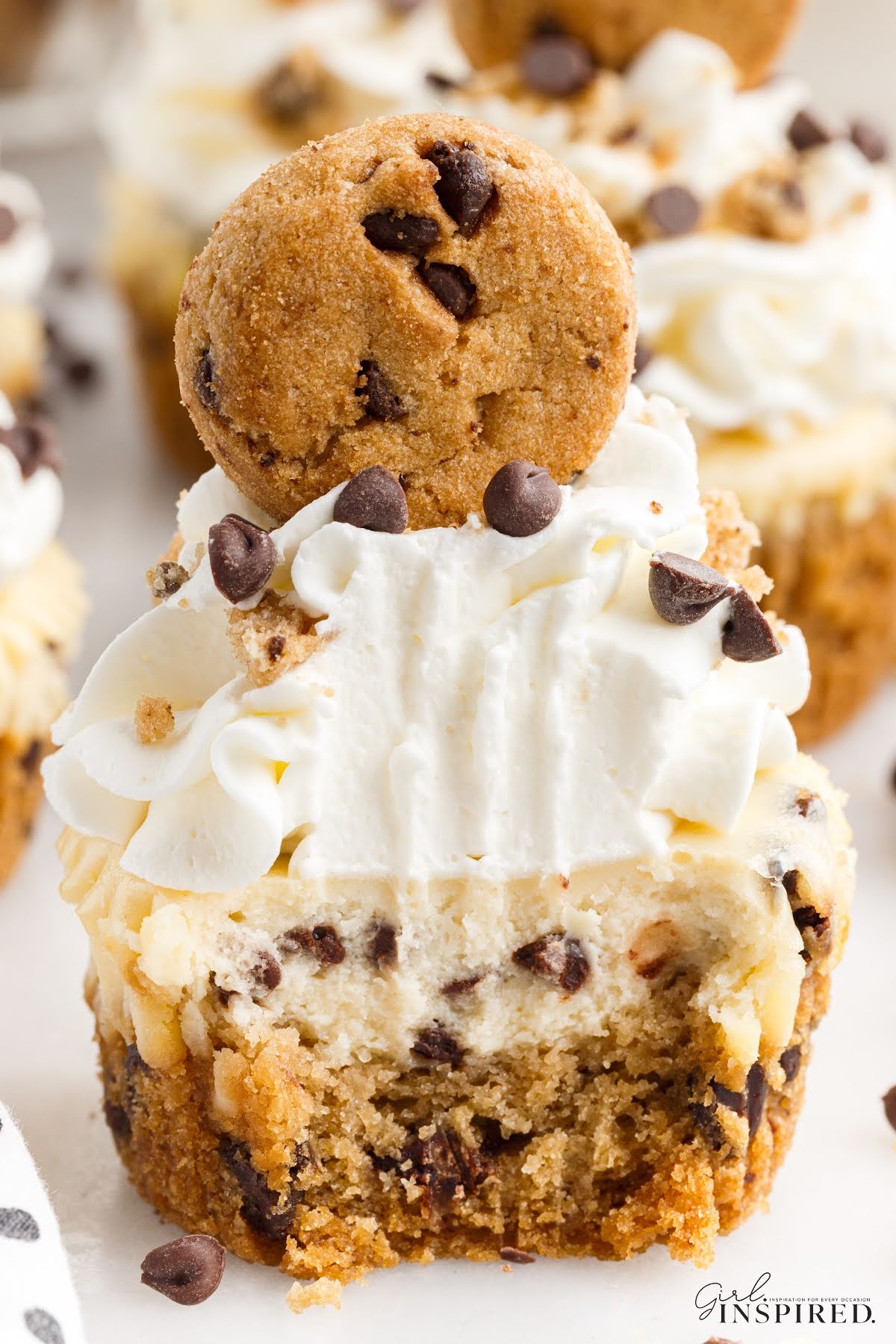 Mini Cookie Dough Cheesecake with whipped cream topping and a mini chocolate chip cookie on top.