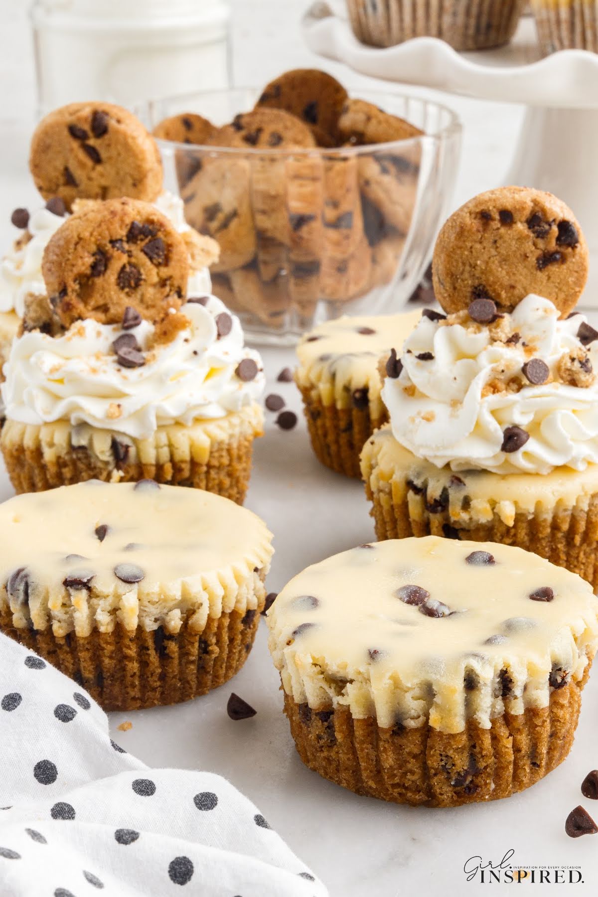 Mini Cookie Dough Cheesecakes with whipped cream topping and a mini chocolate chip cookie on top.
