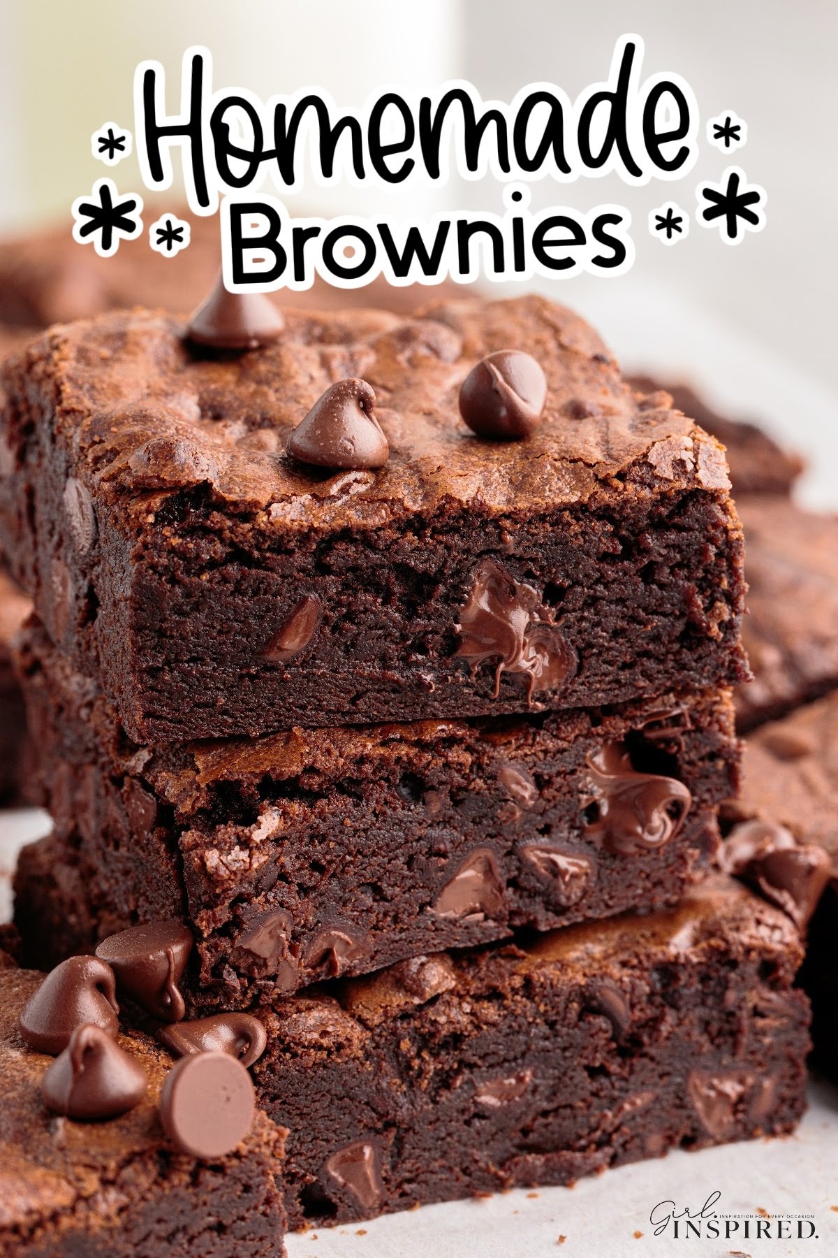 Thick homemade brownies stacked on top of each other.