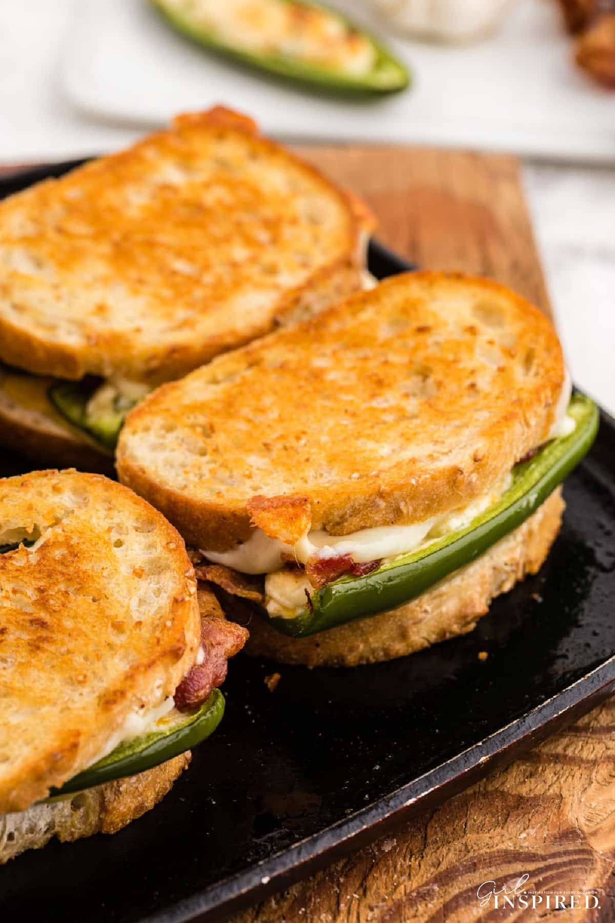 Jalapeño popper grilled cheese sandwiches toasted on metal skillet.