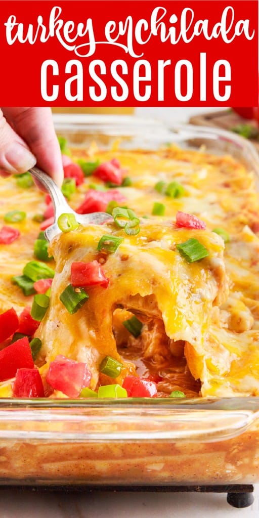 turkey enchilada casserole being scooped out with a spoon from its baking dish