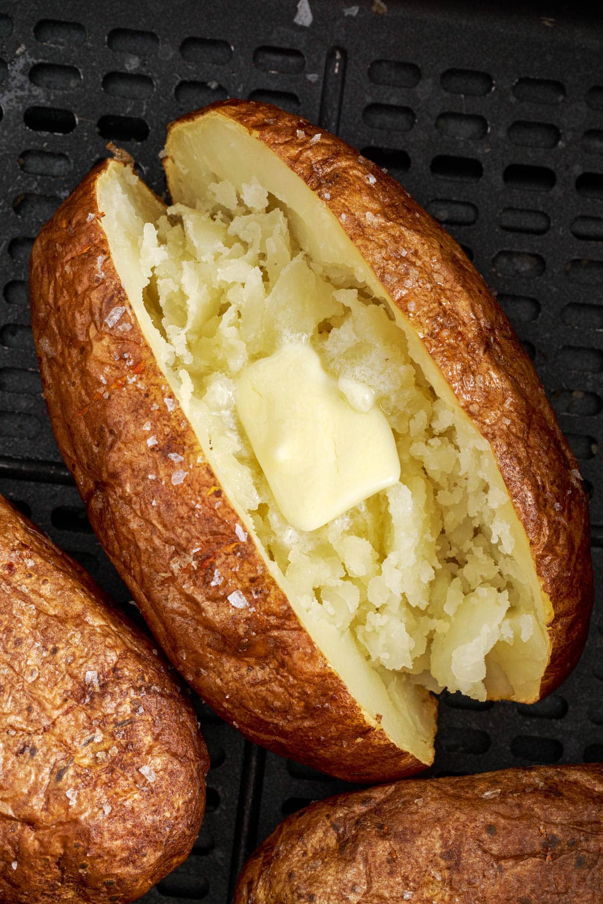 close up of an air fried baked potato with butter