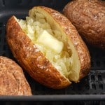 air fried baked potatoes in the basket with butter