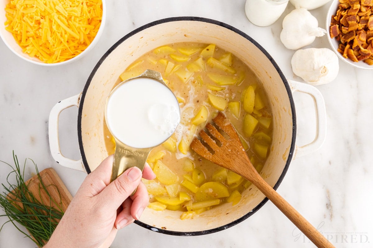 milk added to potato mixture in dutch oven wooden spatula insterted