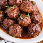 zoomed view of a platter of crockpot meatballs with grape jelly and chilli sauce