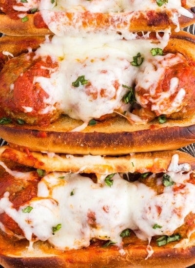 Close up of Meatball Subs topped with melted cheese.