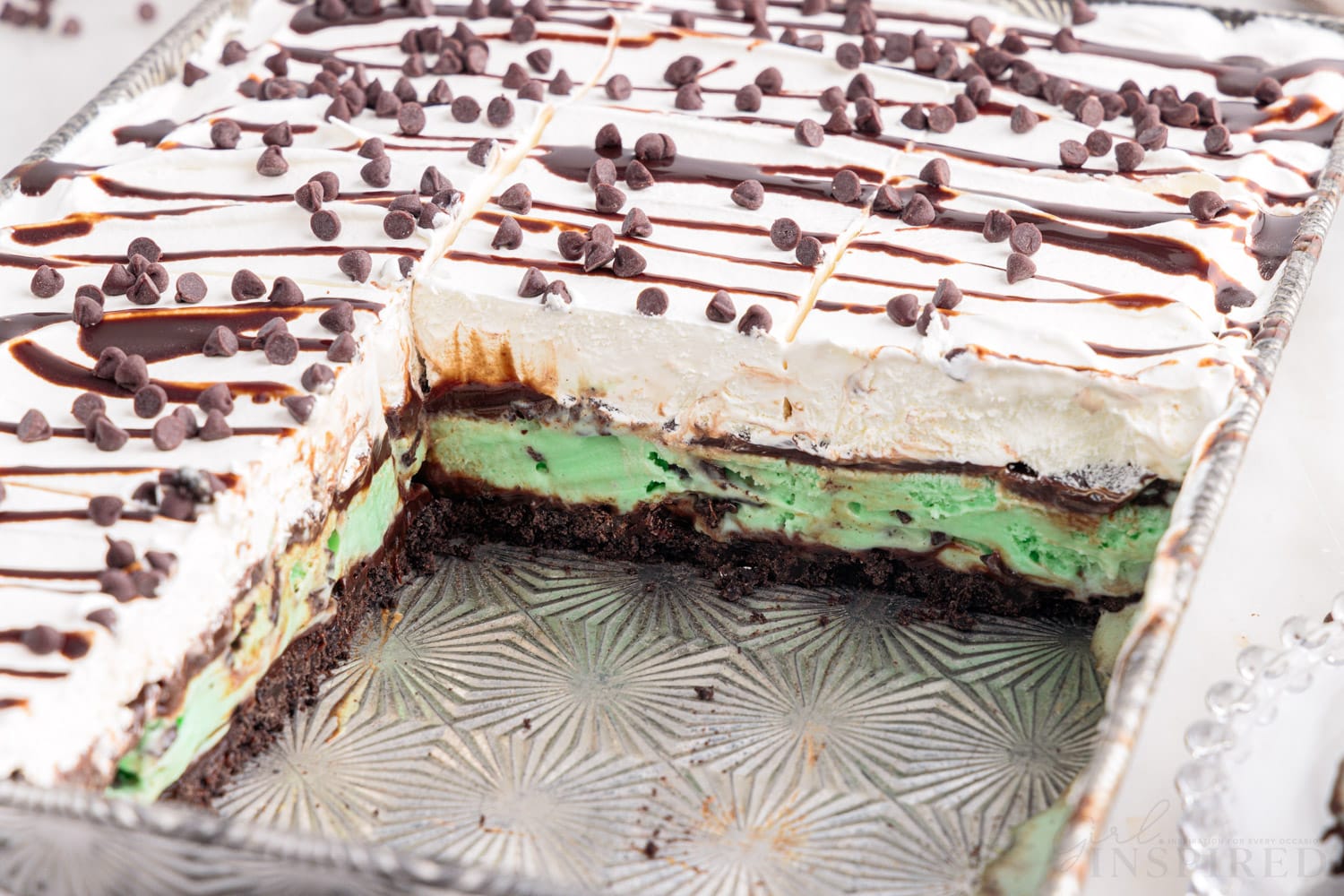 mint chocolate chip ice cream cake with a few slices missing from a 9x13