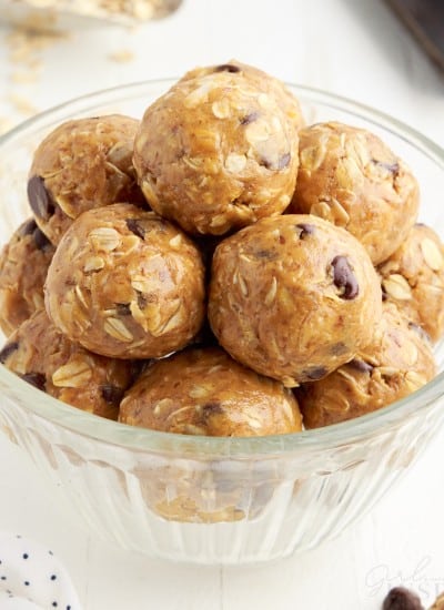 front close up of a small glass dish of no bake peanut butter oat balls.