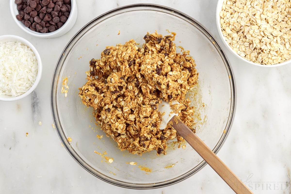 no bake energy ball ingredients mixed together in small mixing bowl with spatula