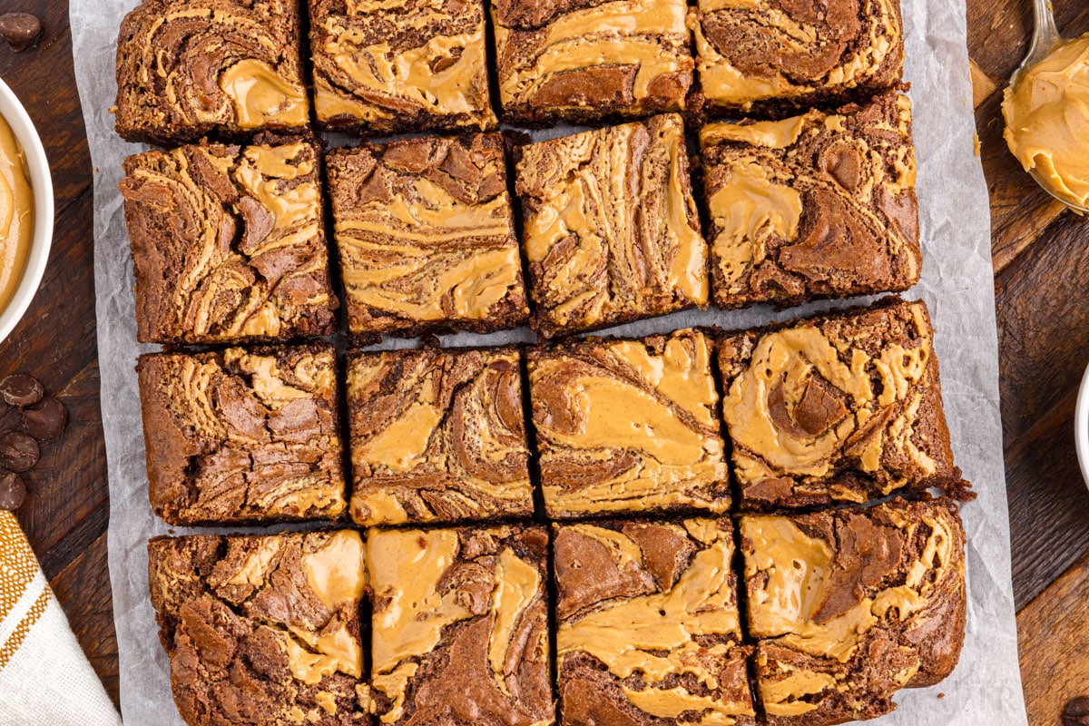 peanut butter brownies cut into squares on parchment paper