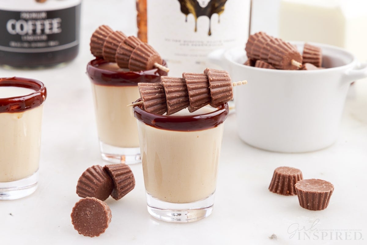 three skrewball whiskey reese cup shots with mini peanut butter cups