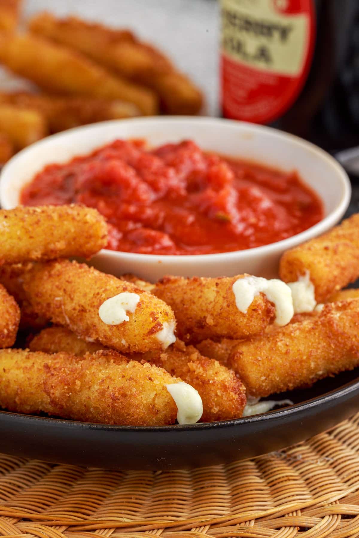 front view of a plate of stuffed ziti fritta with cup of sauce