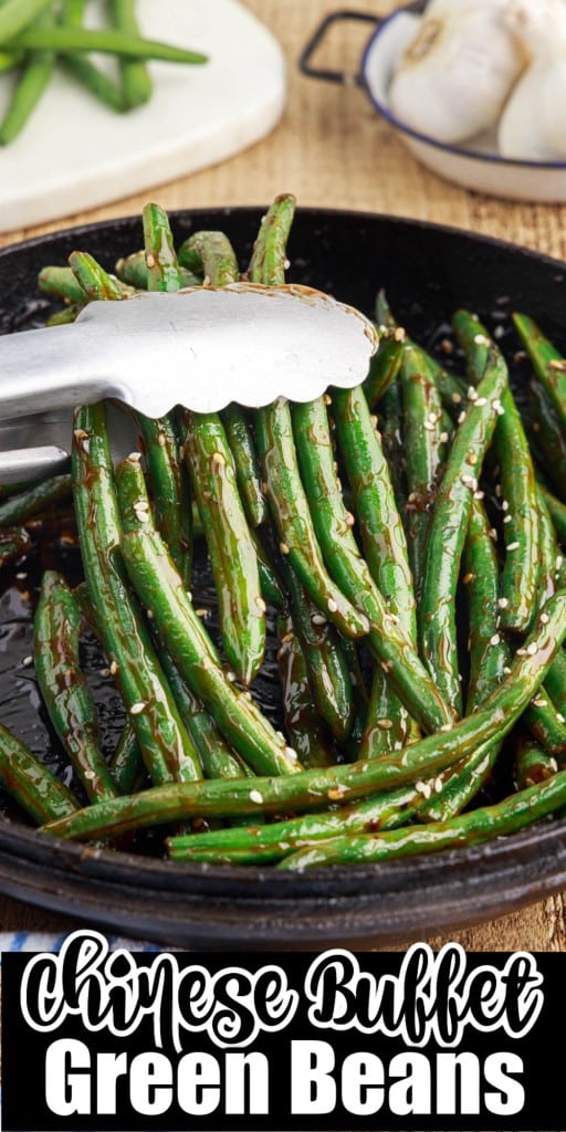 Tongs in a pan of Chinese buffet green beans.